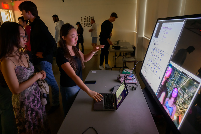 Students interact with digital project at creative computation showcase.