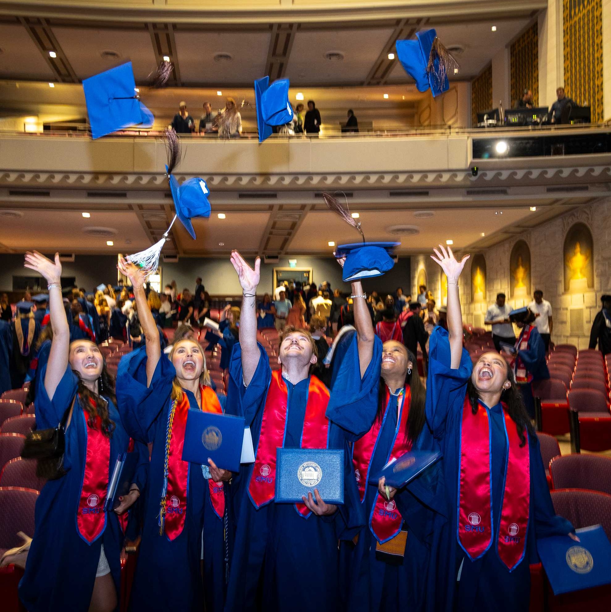 Graduates throw their caps in the air following the degree recognition ceremony